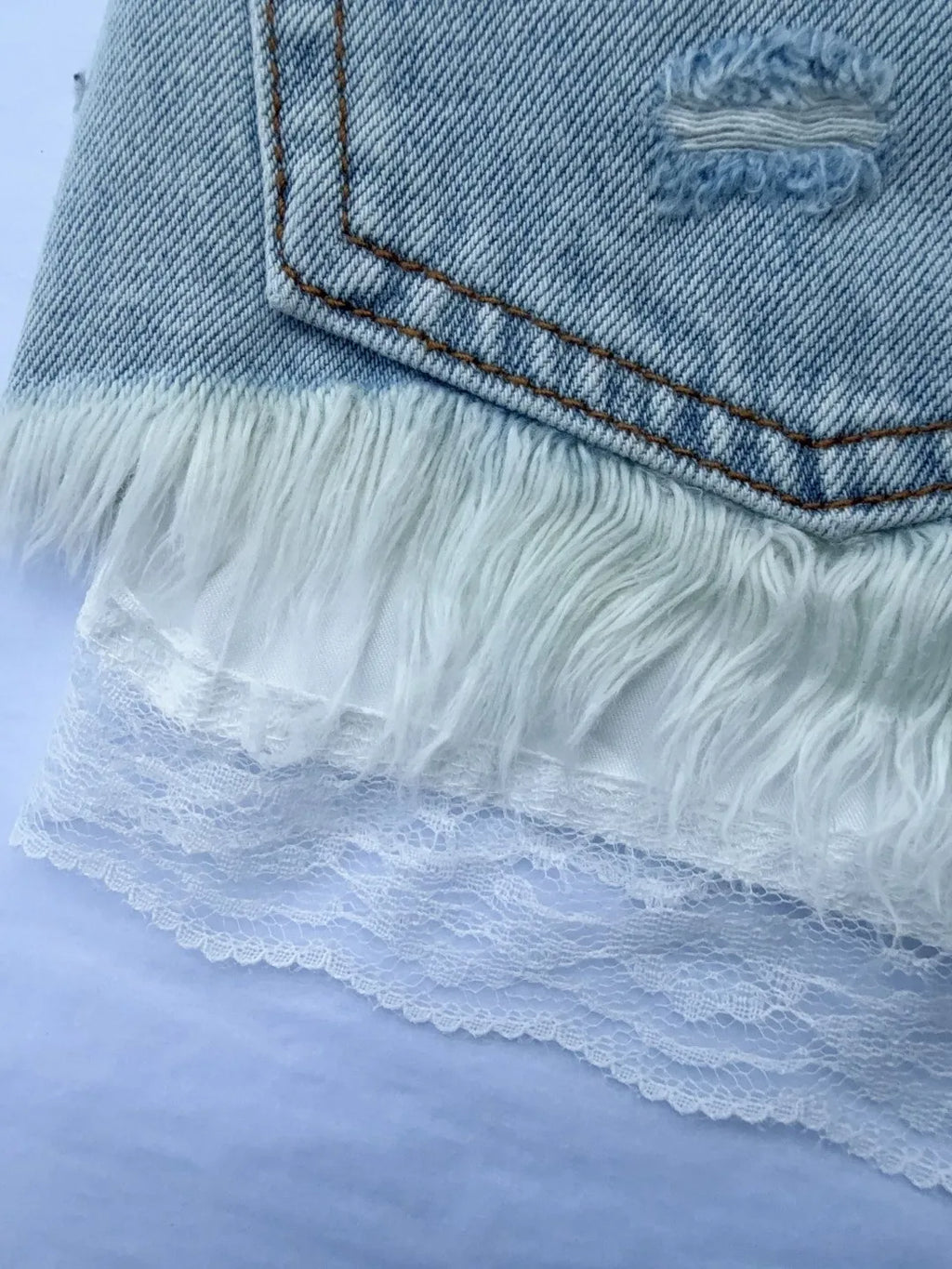 Fake two-piece lace-lined ripped denim shorts